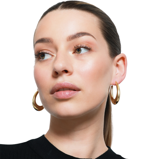 Elegante Frau mit natürlichem Look und goldenen Ohrringen